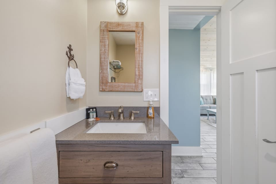 Freshen up in your coastal-inspired bathroom with nautical touches and a weathered wood vanity that brings beachy charm to your morning routine.