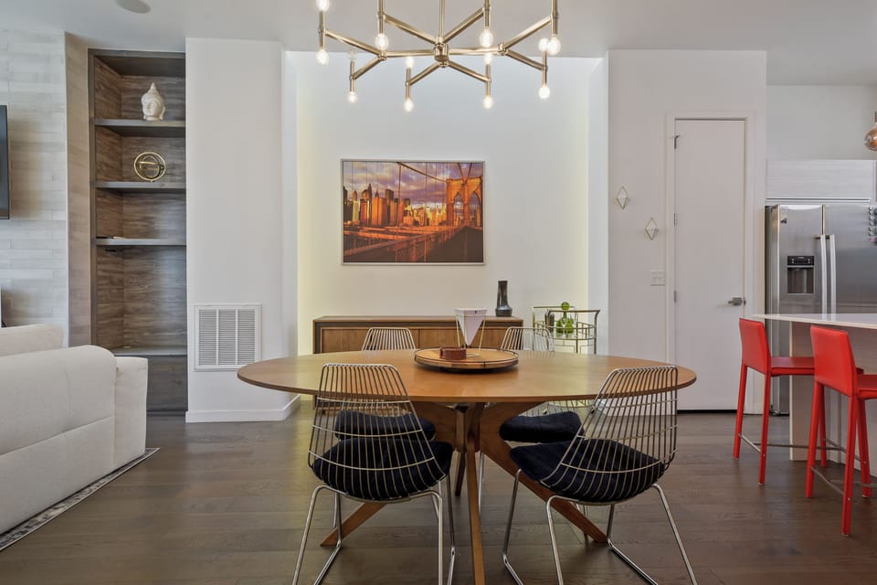Gather around your stylish dining table beneath a modern chandelier, perfect for shared meals and memorable conversations in this open-concept space.