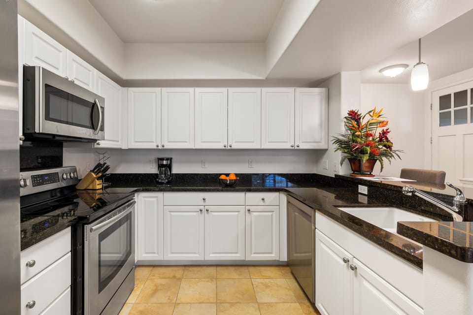 The well-equipped kitchen features granite countertops, stainless steel appliances, and everything needed for meals at home.