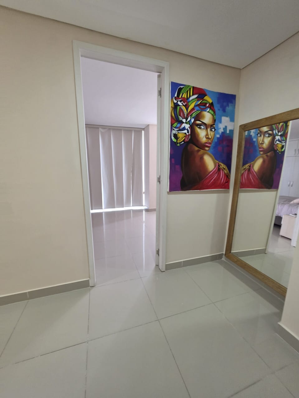 Bright hallway with mirror closet and bold art accent.