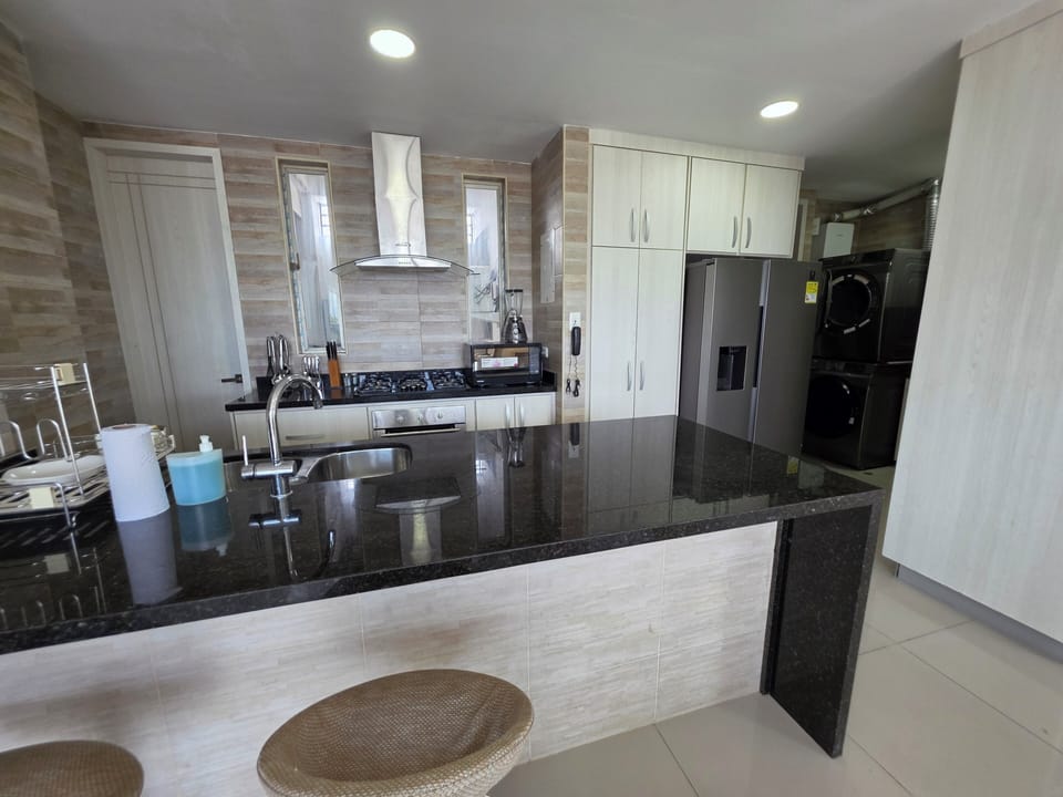 Sleek kitchen with granite island, gas range, and in‑unit laundry.