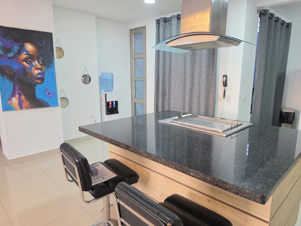 Sleek kitchen island with granite, bar seating & bold art accent