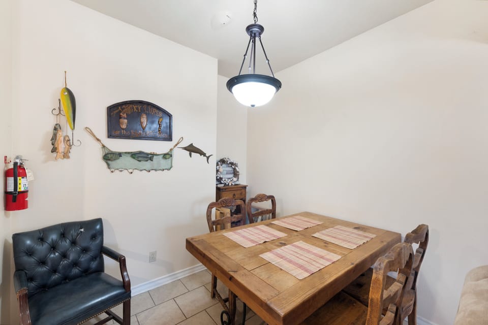 Gather around this rustic dining table where your mornings start with coffee and conversation. The fishing-themed décor adds character and charm to your shared meals together.