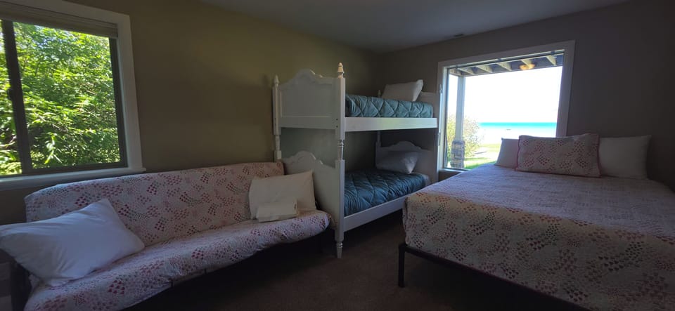 Spacious bunk room with futon, queen bed, and water views