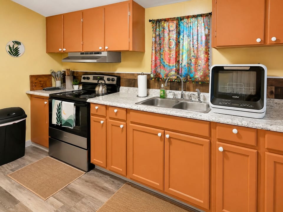 Bright, cheerful kitchen with full stove, double sink, and ample counter space