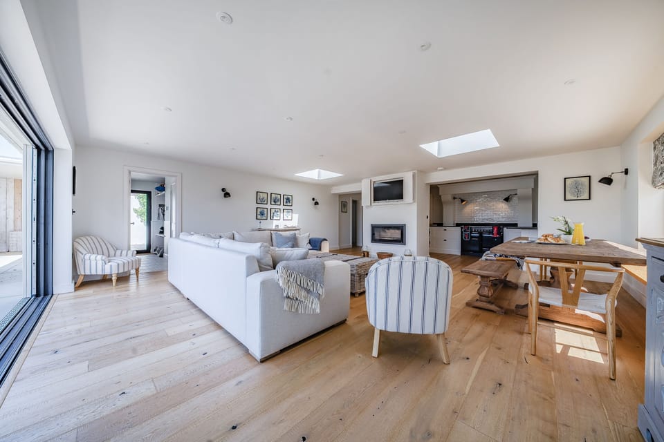 The Anchorage, Burton Bradstock: The open-plan day space with sitting and dining space, and the kitchen beyond