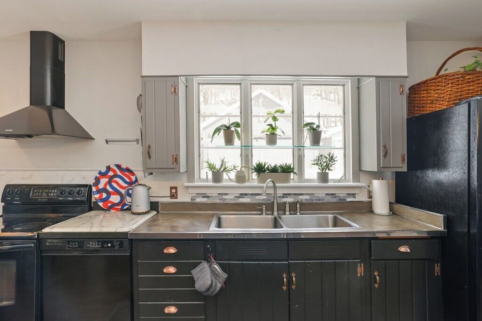 Farmhouse kitchen sink area with large window, natural light, and peaceful views of the surrounding greenery.