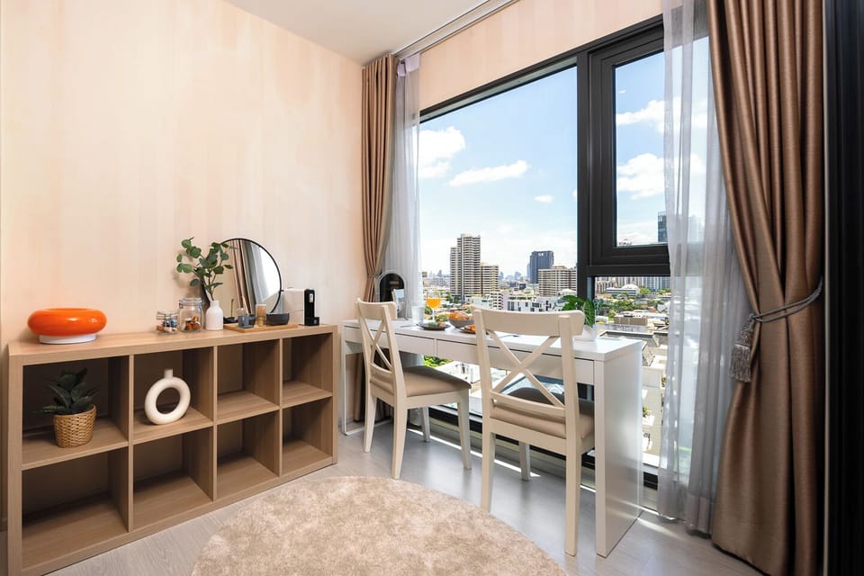 【Work From Home with a Bangkok View】Desk and two chairs sit directly at the window with an unobstructed city skyline view. The Nespresso machine. Fast WiFi, a proper chair, and Bangkok in front of you. Genuinely good remote working setup.