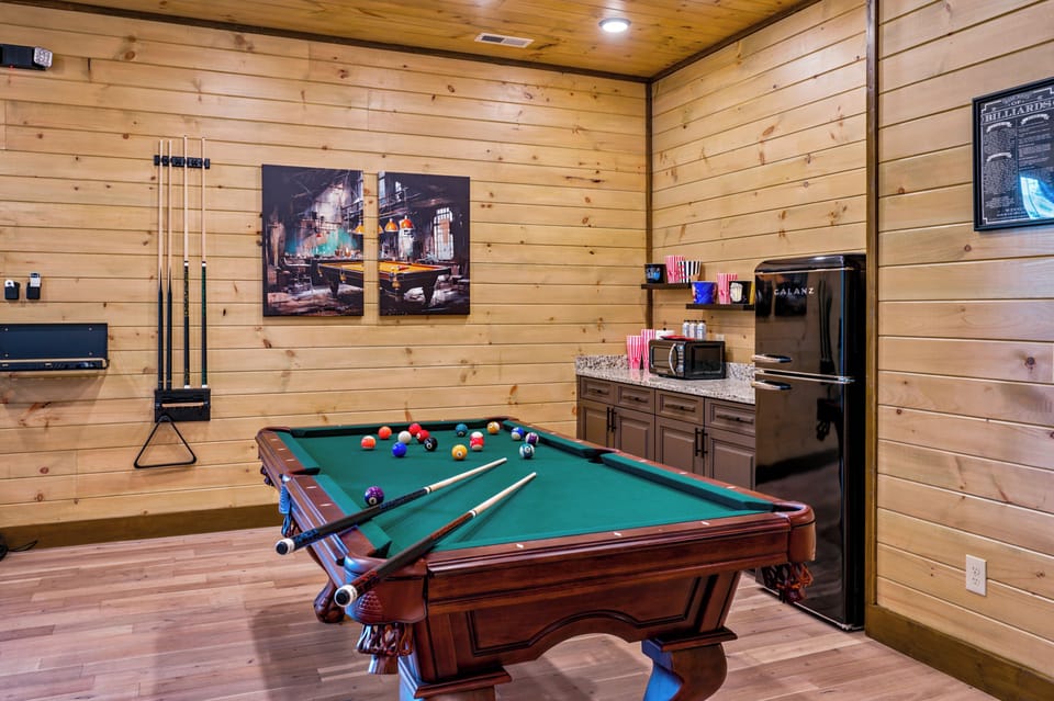 Rustic game room with pool table, mini fridge, and snack bar