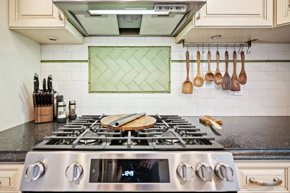 Gourmet kitchen featuring gas range, custom finishes, and fully stocked cooking essentials