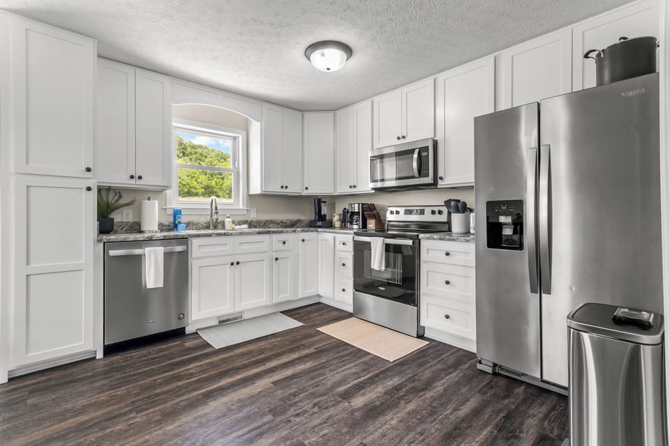 Large kitchen stocked with pots, pans, other cooking essentials, basic spices & more!