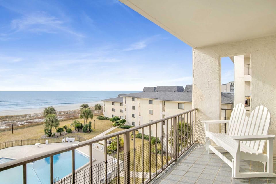 Oceanview balcony with cozy seating and pool access