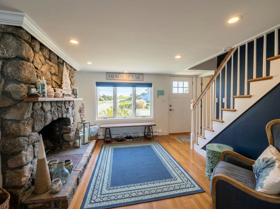 Welcoming entry with stone fireplace and bright coastal charm