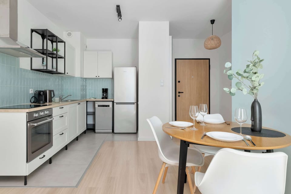 Stylish kitchenette with modern appliances and a dining area, designed for comfortable everyday living.