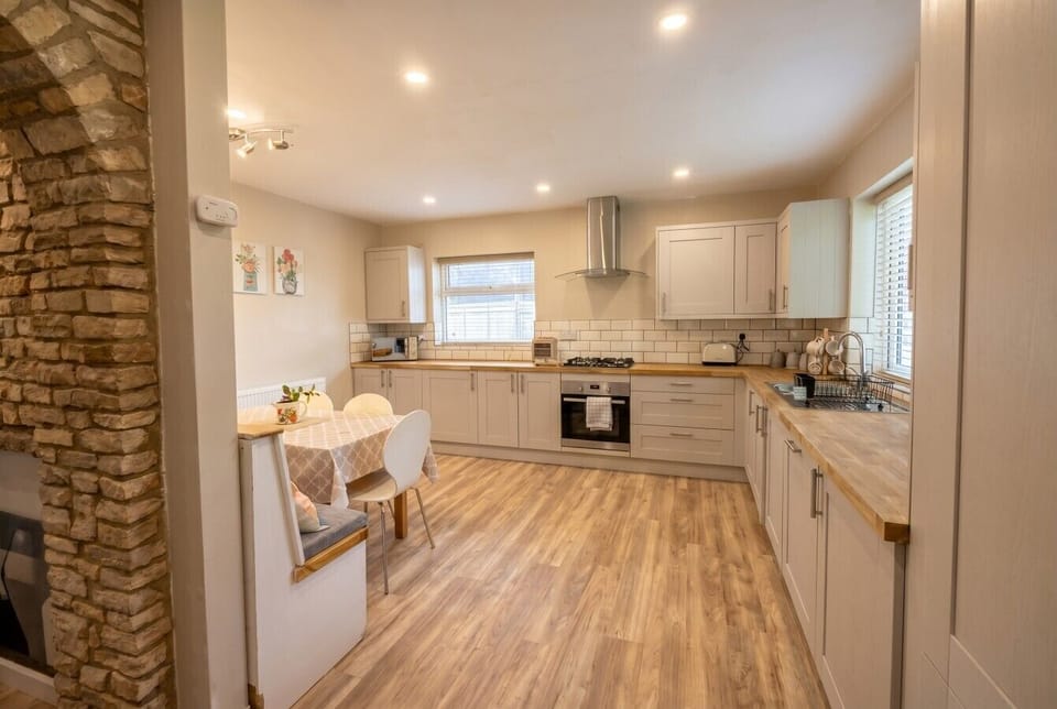 Generous kitchen with breakfast bench and exposed stone surround