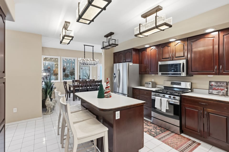 Beautiful oversized kitchen with eat-in counter and family dining area, sun room overlooking back patios and expansive yard