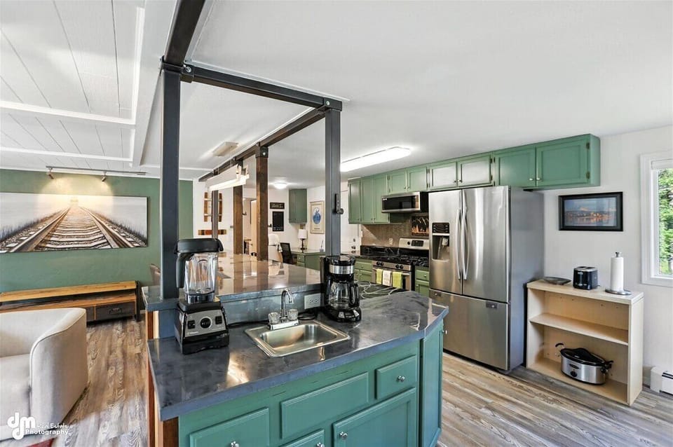 Wet bar in center of great room extends kitchen for coffee, cocktails, or just extra counter space