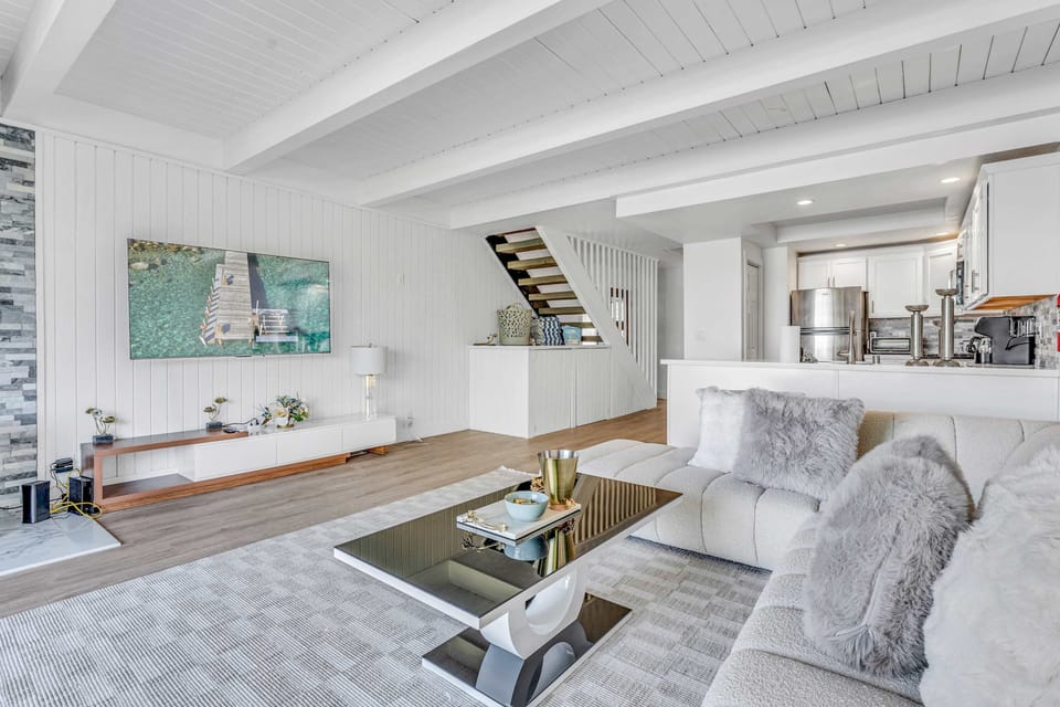 Living room: Standalone gas fireplace, TCL 4K QLED Smart TV, balcony access