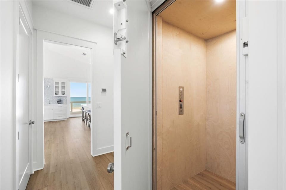 The elevator or the stairs can take you to the top floor of the house, which features vaulted ceilings, the main kitchen and living room, a king bedroom, and the primary suite.