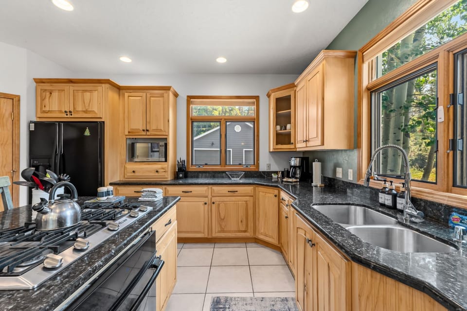 Kitchen: Gas range, drip coffee maker, Keurig coffee machine, Crockpot, blender, kettle, cooking utensils, and tableware