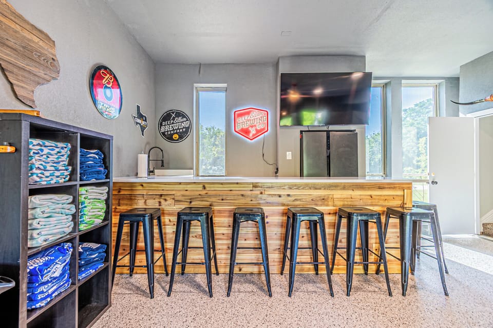 Bar in the game room with sink and large fridge.  Perfect spot to set up the snacks or the food line