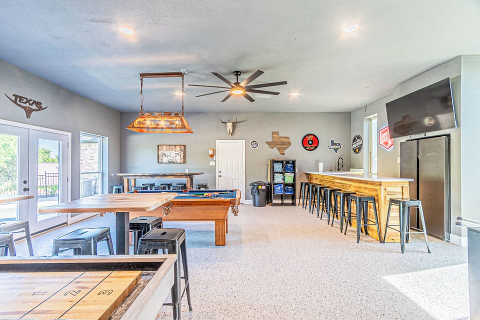 Over-sized game room provides a great place to gather at night or to cool off during a hot summer day.  It is located in the guest house with 2 bedrooms, bathroom, living space and small kitchen located above it