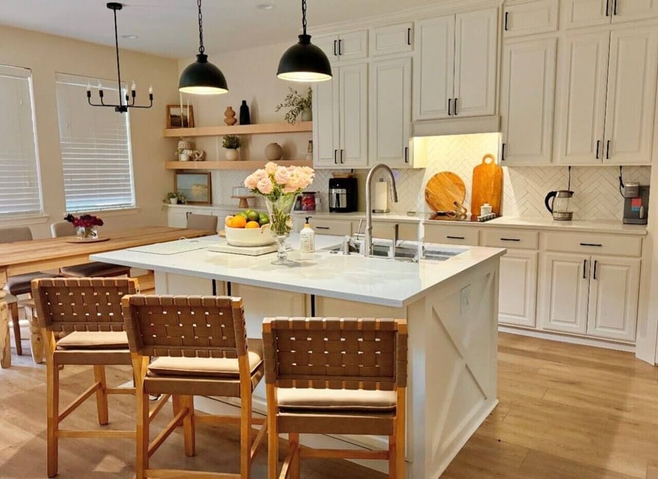 Modern kitchen with island seating and premium finishes — gather around while dinner comes together.