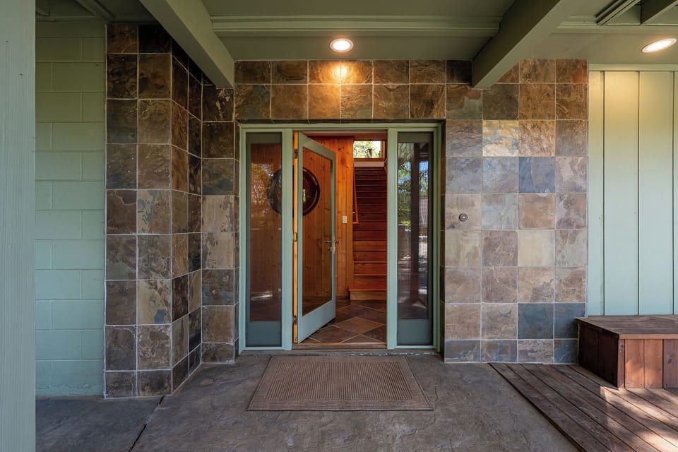 Welcoming covered entry with stone accents and warm wood details
