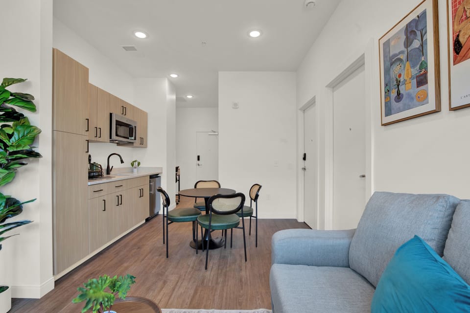 Bright modern studio with kitchenette, dining nook, and cozy seating