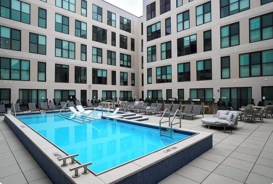 Modern courtyard pool with resort-style loungers and spacious sun deck