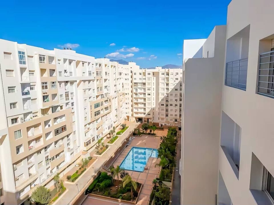 Residence Islane GH25 courtyard view with shared swimming pool, landscaped gardens and secure residential surroundings.
