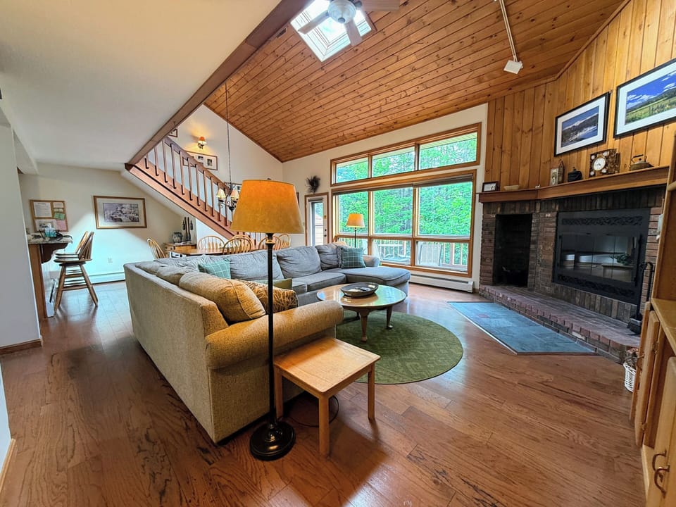 Main living space offers a comfortable sectional, wood burning fireplace, and TV.