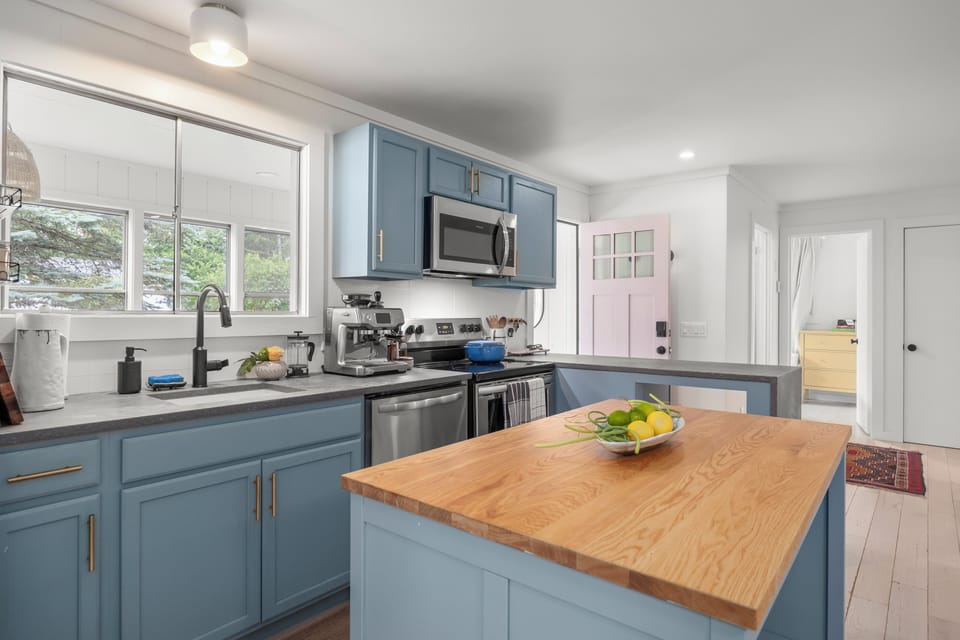 Bright designer kitchen with blue cabinets and butcher-block island