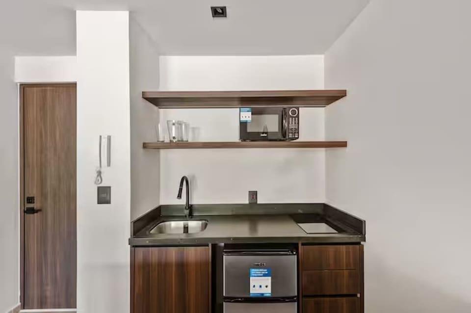 Functional and stylish kitchenette. Features beautiful local wood cabinetry, modern countertops, an induction cooktop, and essentials for preparing meals during your stay.