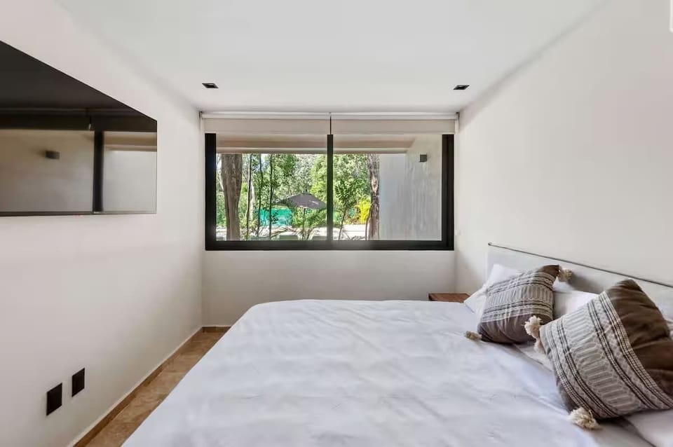Private bedroom sanctuary. Unwind on a plush King-size bed with floor-to-ceiling glass doors that open up directly to your private terrace and pool.
