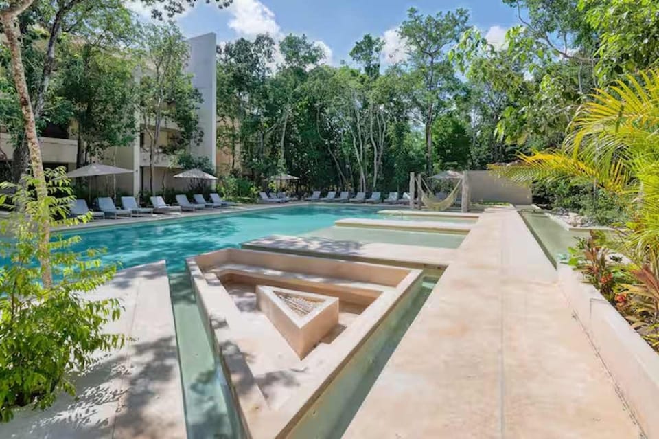 Sunken fire pit lounge seamlessly integrated into the complex's water mirrors. A stunning, avant-garde architectural space ideal for magical evenings under the stars.
