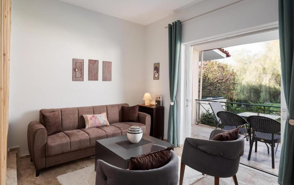 Bright and comfortable living area featuring modern furnishings, natural light, and direct access to a private balcony overlooking the surroundings.