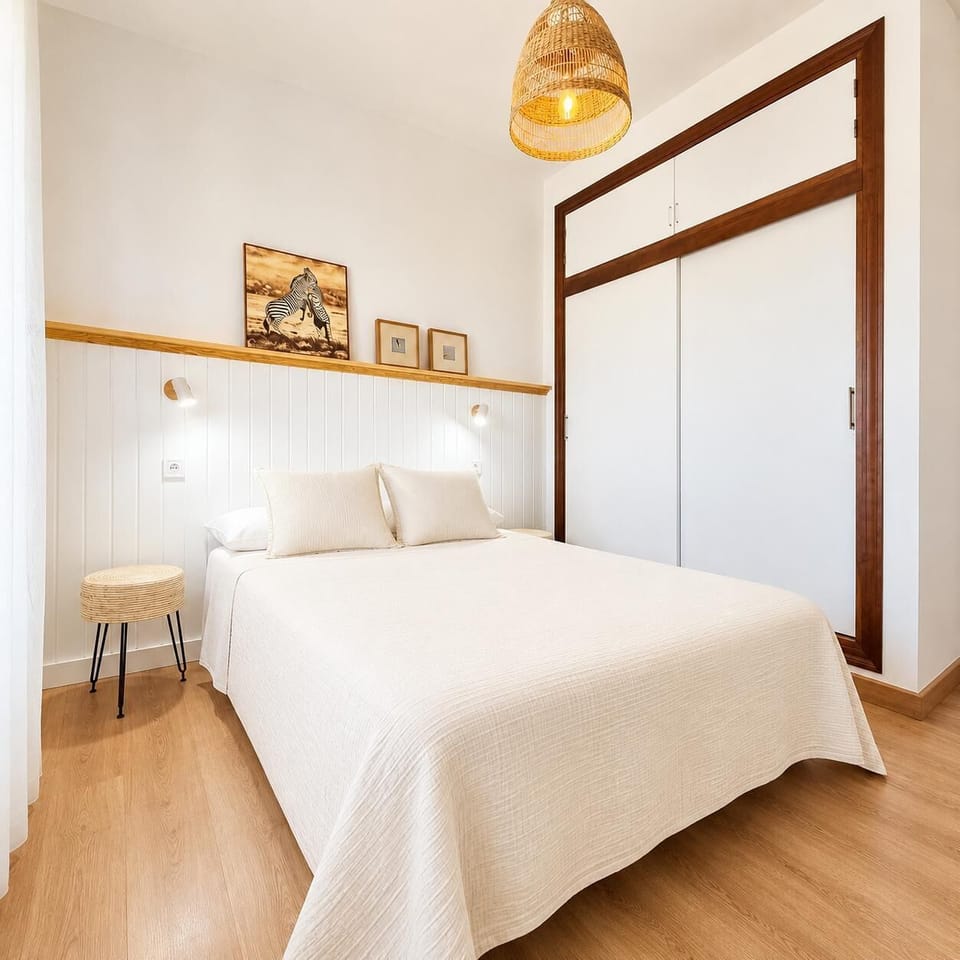 A cozy neutral bedroom with wooden accents and a modern built-in wardrobe.