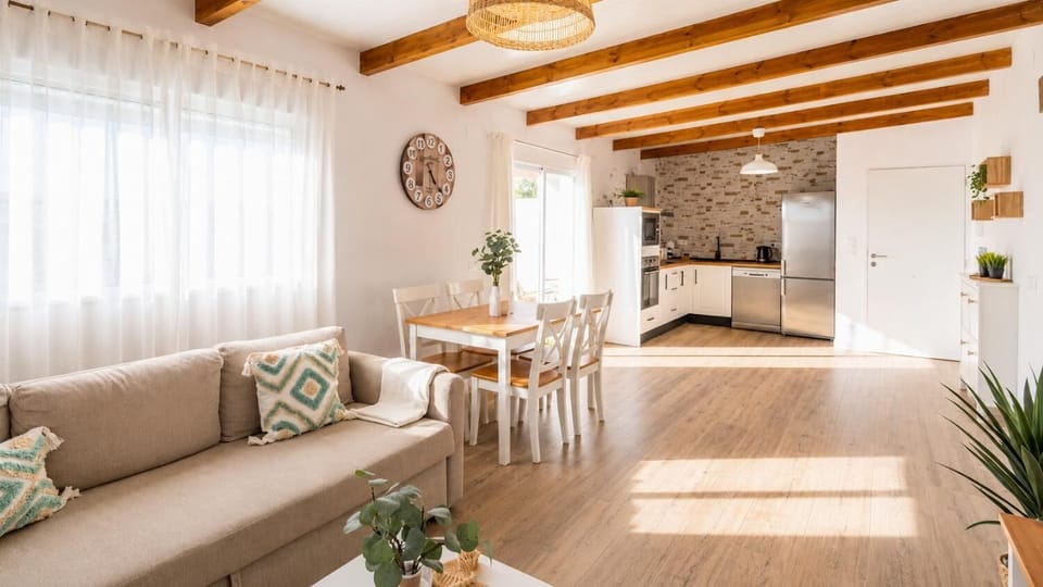A bright open-plan living space with a cozy sofa, dining area, and modern kitchen.