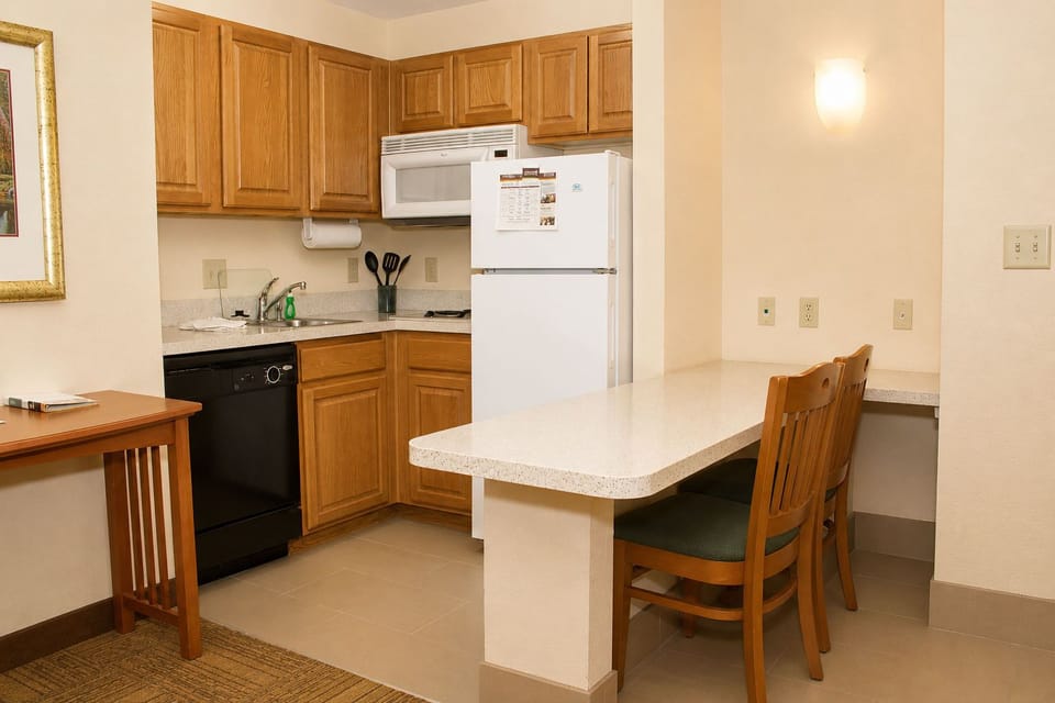 Fully equipped kitchen with modern appliances and seating for two.