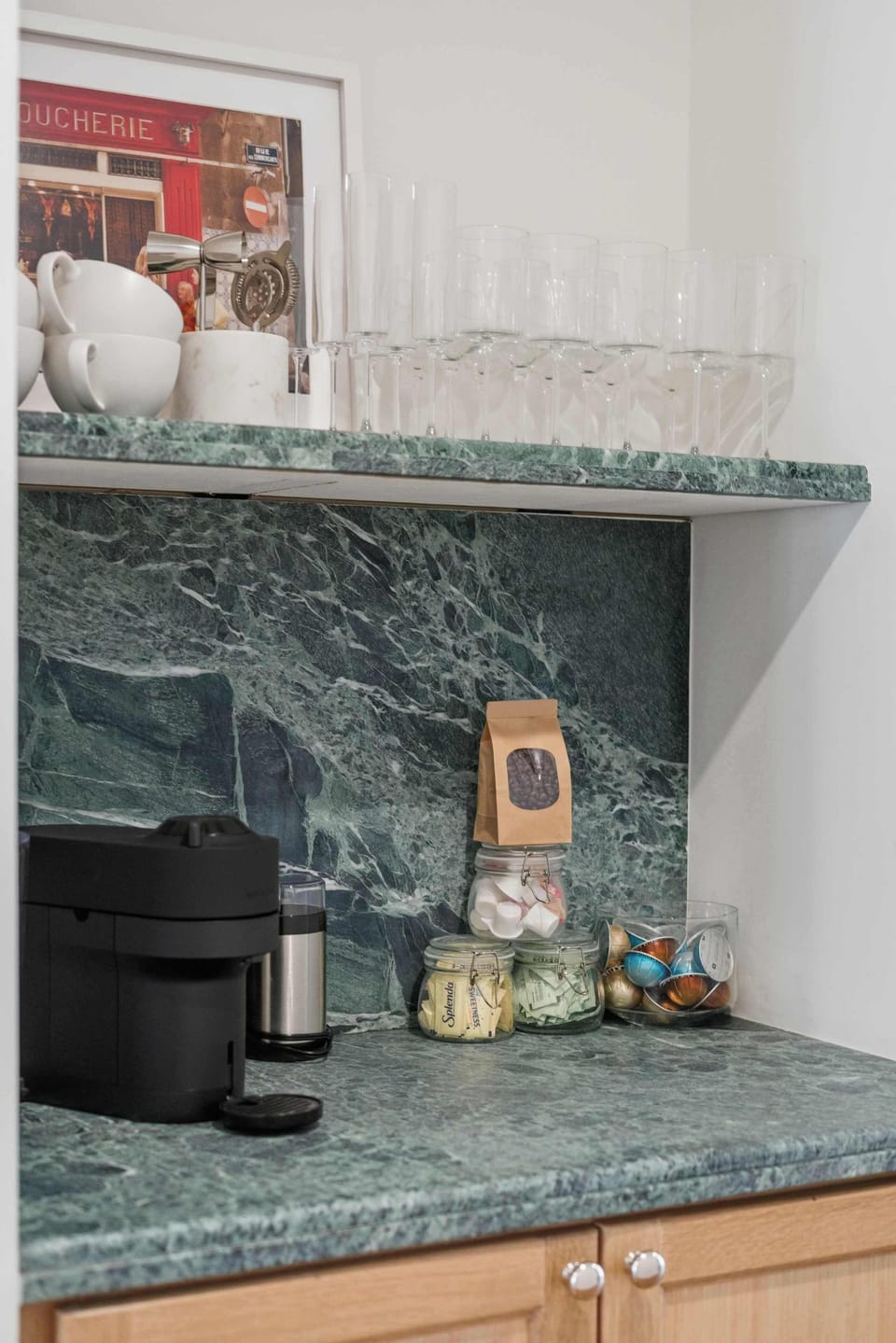 Coffee and beverage station with Nespresso machine, wine glasses, and green marble shelving