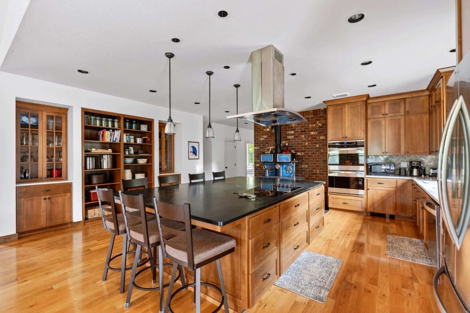 Kitchen with island seating and library wall.