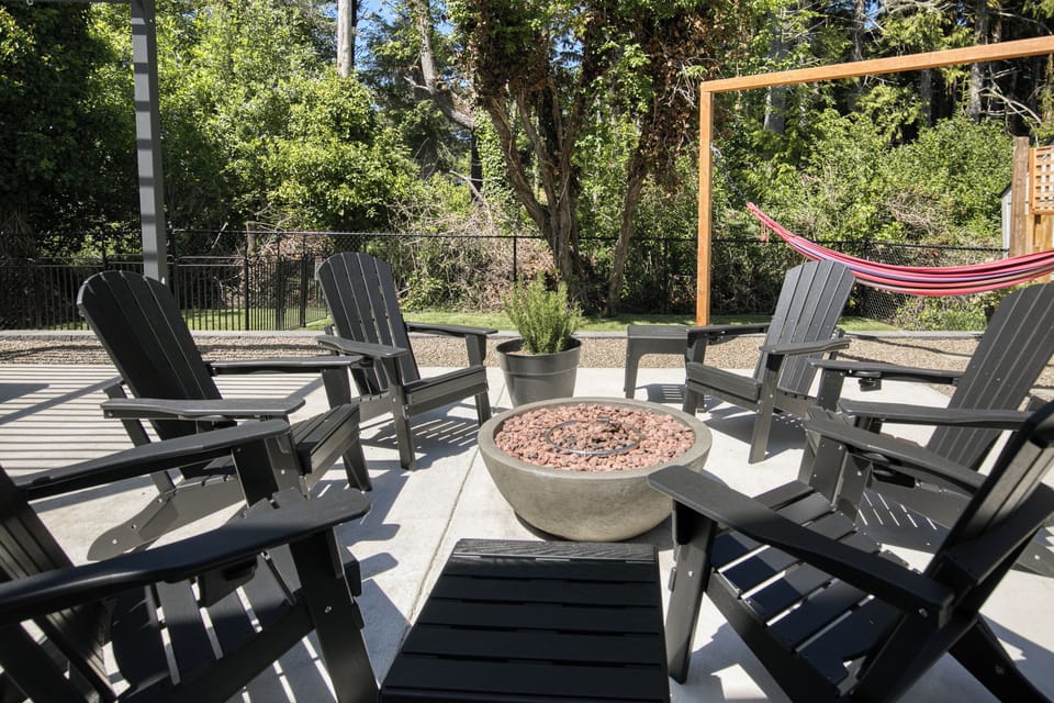 Gather around the fire! This dedicated patio lounge area features comfortable Adirondack chairs surrounding a clean gas fire pit bowl—the ultimate spot for evening conversations and roasting marshmallows.