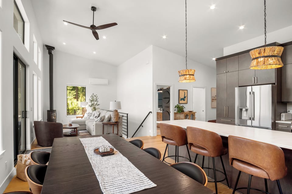 Bright open-concept living with vaulted ceilings, fireplace, and modern kitchen
