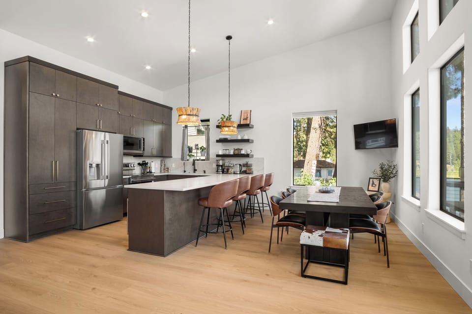 Bright modern kitchen with waterfall island, bar seating, and airy dining area