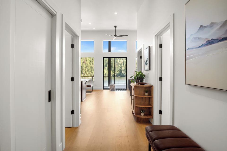 Bright modern entryway with soaring ceilings and serene forest views