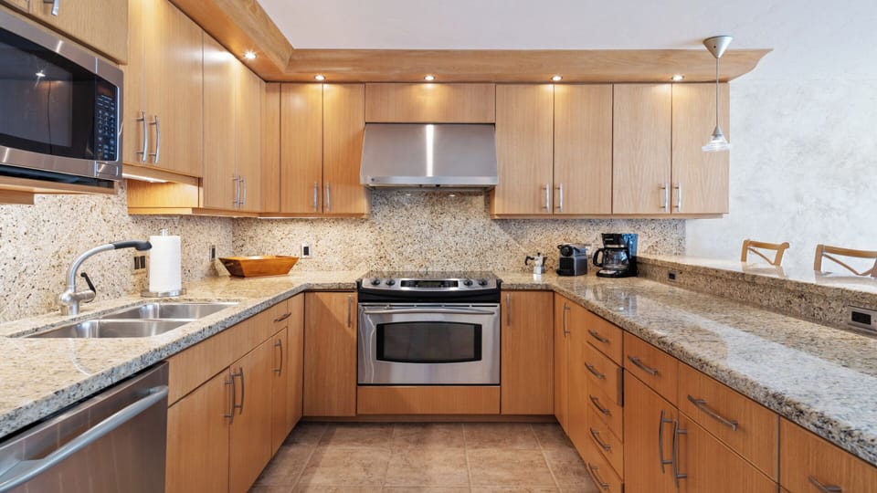 Your fully equipped kitchen awaits with sleek granite countertops, stainless steel appliances, and warm wood cabinetry—perfect for preparing home-cooked meals during your stay.