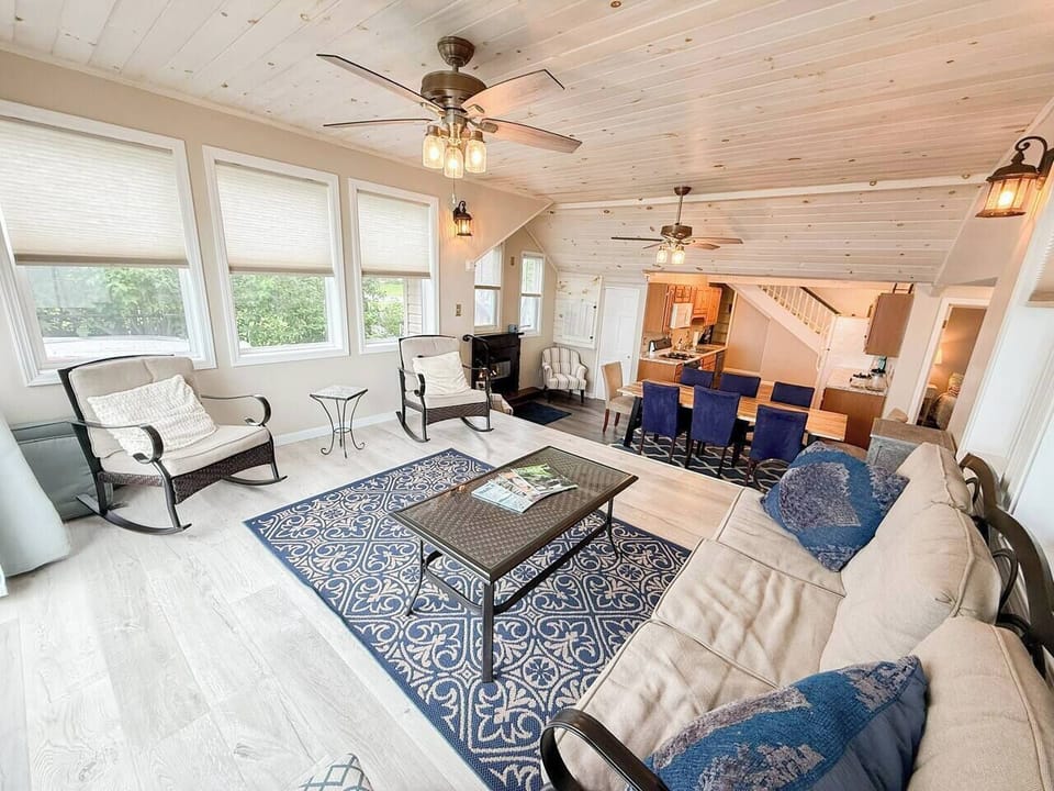 Sink into relaxation after a day on the water — rockers, a gas fireplace, and windows full of green surround you. The dining table and kitchen are just steps away.