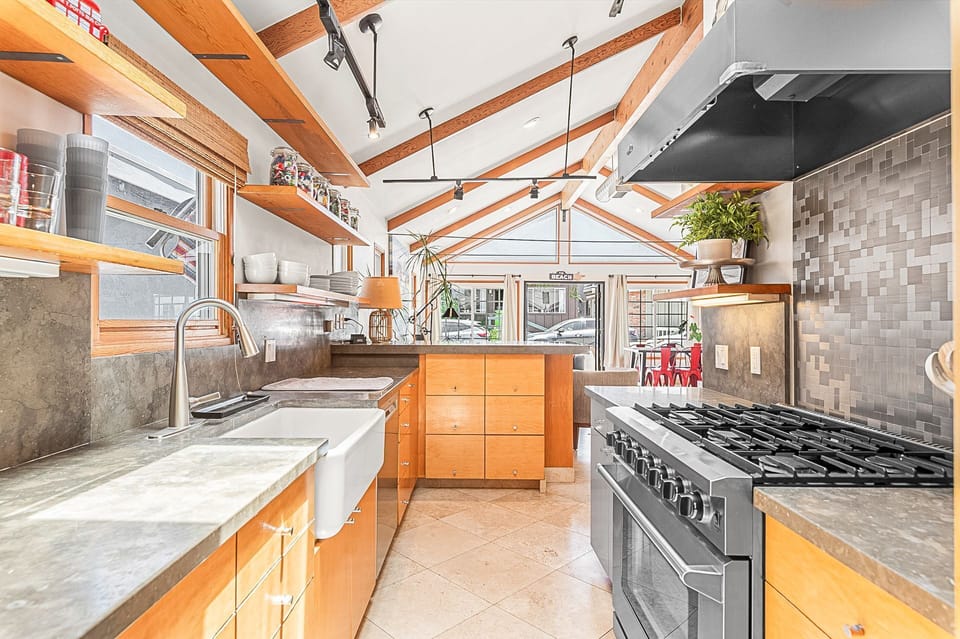 Gourmet kitchen featuring stone countertops, open shelving, and a premium six-burner gas range
                