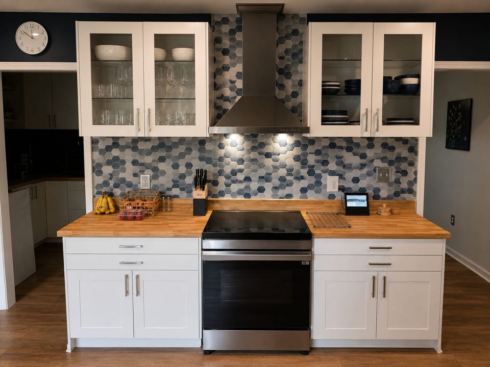 Kitchen cooking area with butcher block counters, full-size range, microwave and colorful tile backsplash.